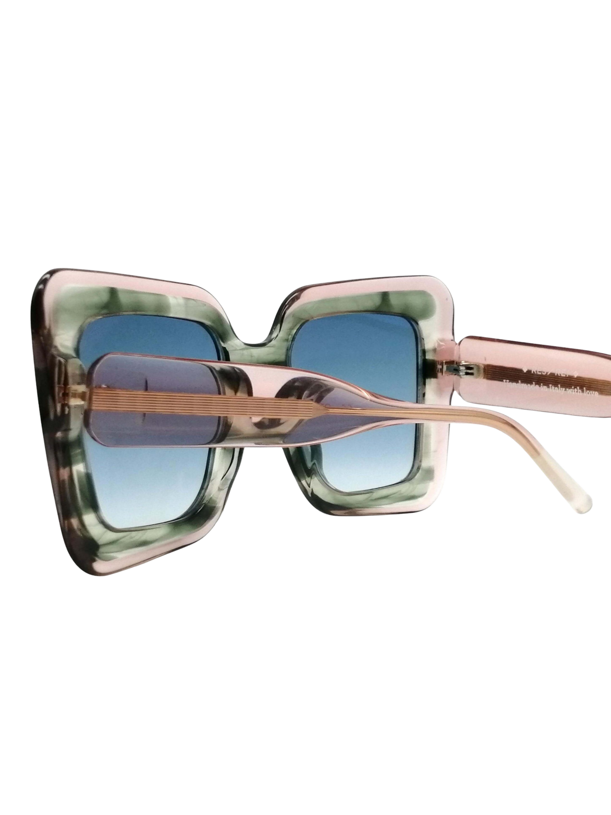 sunglasses with a marbled green and pink frame and blue gradient lenses